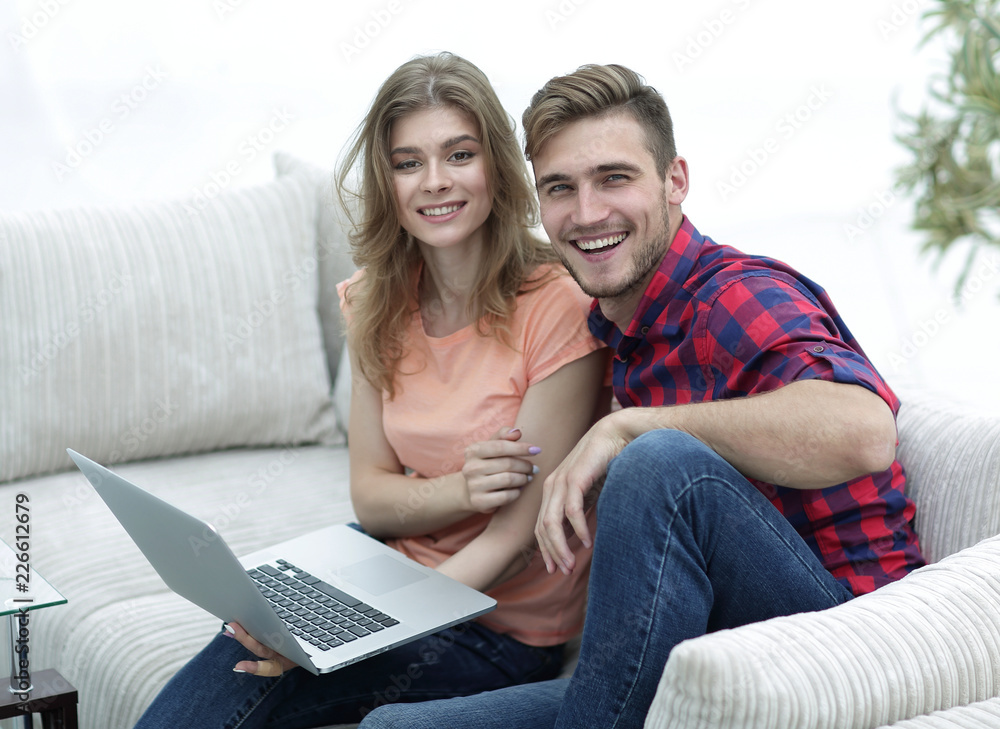 pair students with a laptop sitting on sofa pair students with a laptop sitting on sofa