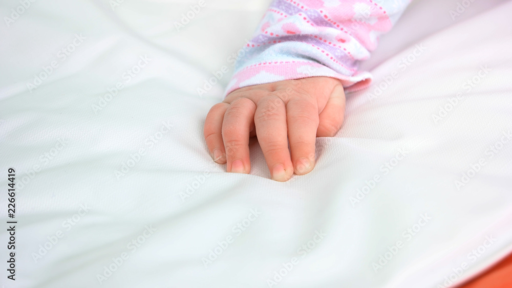 Hand of infant baby girl. Hand of newborn caucasian kid on white blanket. Softness of skin. Hand of infant baby girl. Hand of newborn caucasian kid on white blanket. Softness of skin.