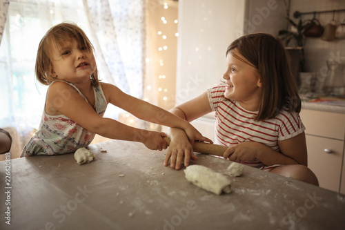 Принти на полотні Children in real kitchen make dough and swear