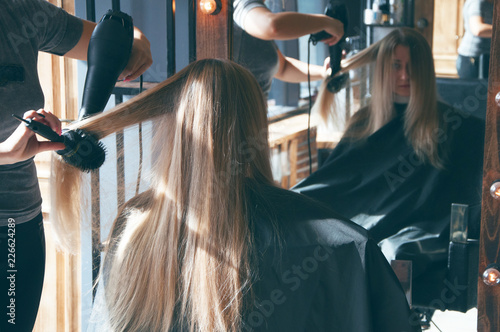 A beautiful european blonde girl doing a hairstyle in a beauty salon