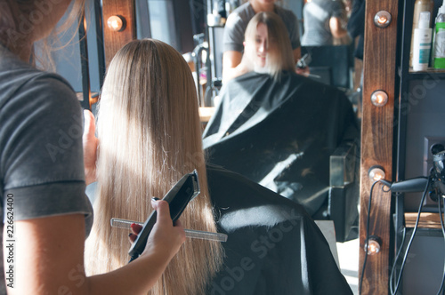A beautiful european blonde girl doing a hairstyle in a beauty salon