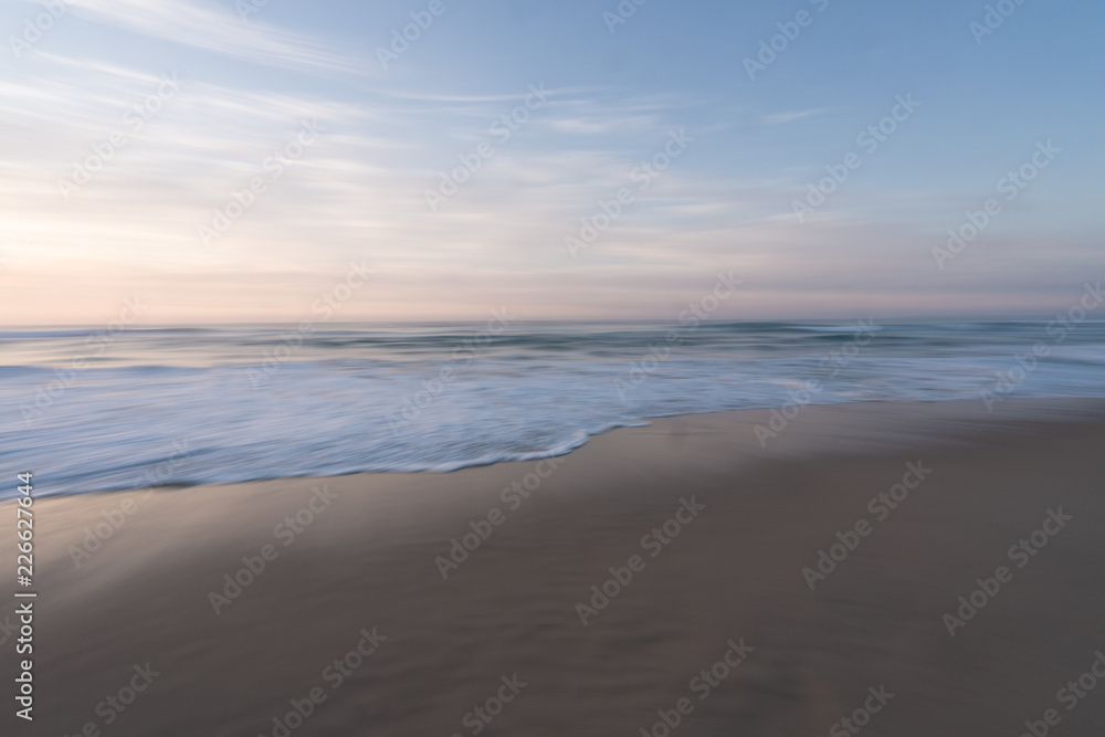 Soft pink sunrise over the beach with motion blur