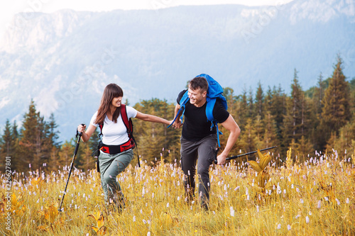 Young hikers couple with backpack on mountain 