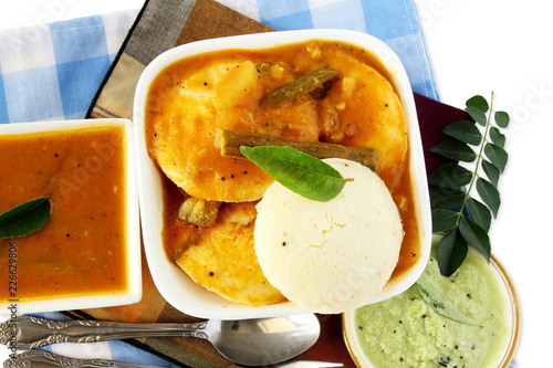 Popular South indian breakfast food Idly sambar or Idli rice and lentils steamed cakes with spicy soup Sambhar and green coconut chutney 