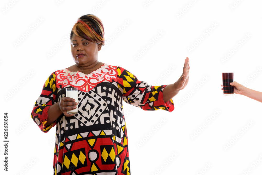 Studio shot of fat black African woman holding glass of milk whi Studio shot of fat black African woman holding glass of milk whi