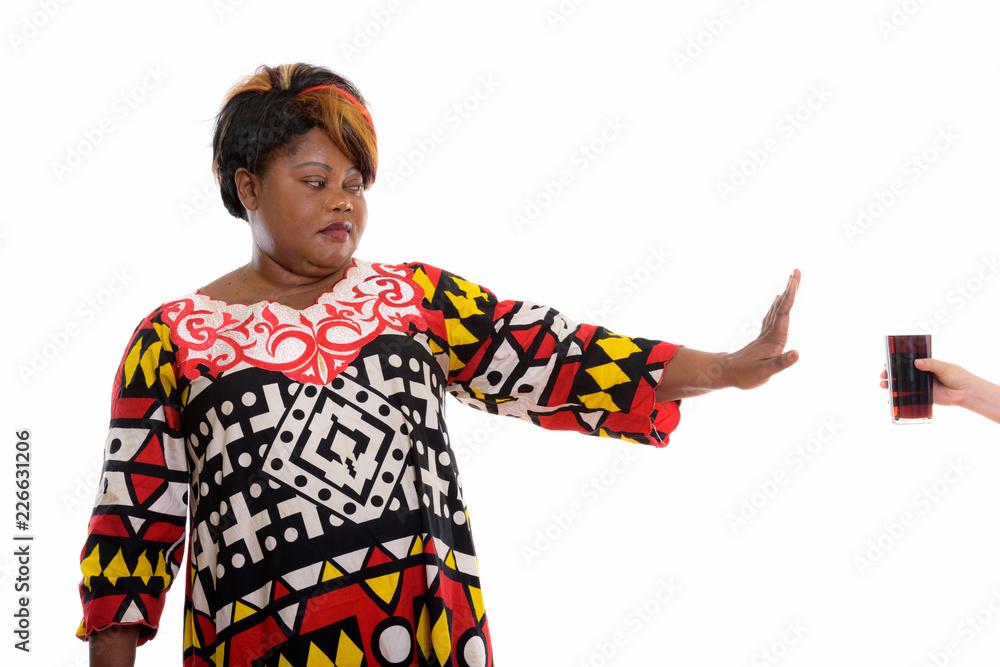 Studio shot of fat black African woman rejecting glass of soda d Studio shot of fat black African woman rejecting glass of soda d