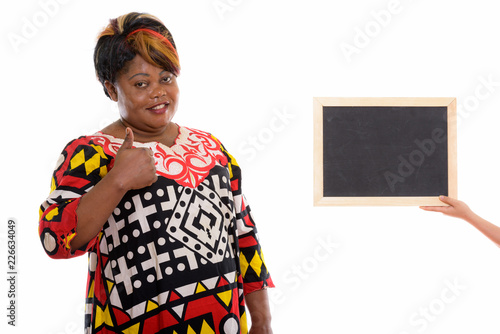 Studio shot of happy fat black African woman smiling while givin