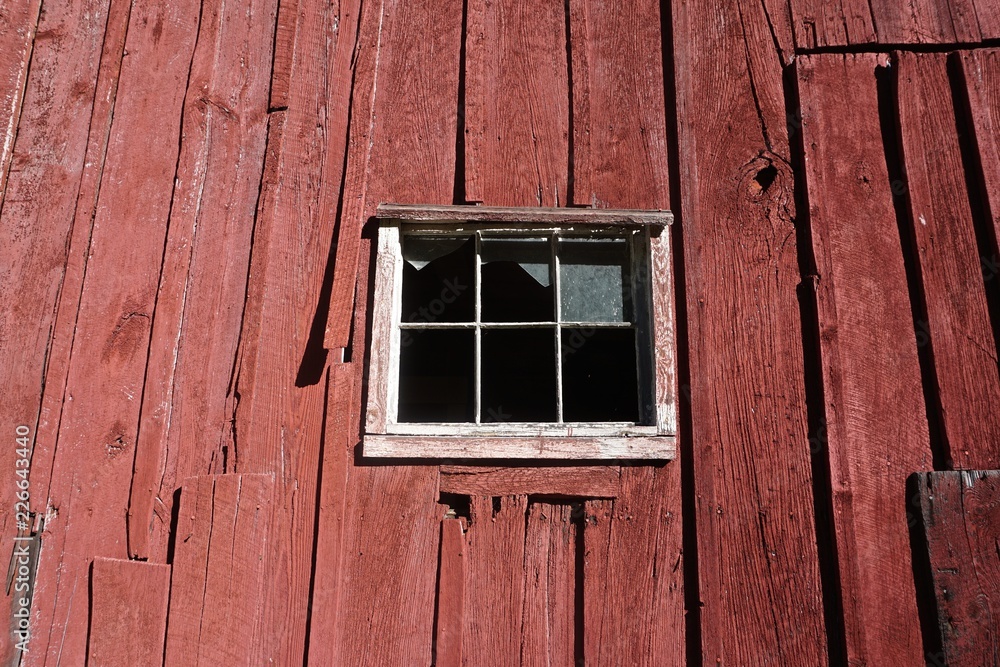 Pocono Mountains, Pennsylvania, USA: The window of an abandoned red barn with broken glass and peeling red paint. Pocono Mountains, Pennsylvania, USA: The window of an abandoned red barn with broken glass and peeling red paint.