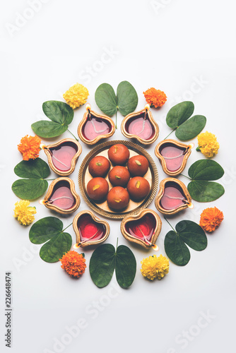Happy Dussehra   Vijayadashami   Ayudh Puja greeting card using apta Bauhinia racemosa Bidi leaf and indian sweet Rasgulla or Gulab Jamun for Navaratri along with Diya oil lamp