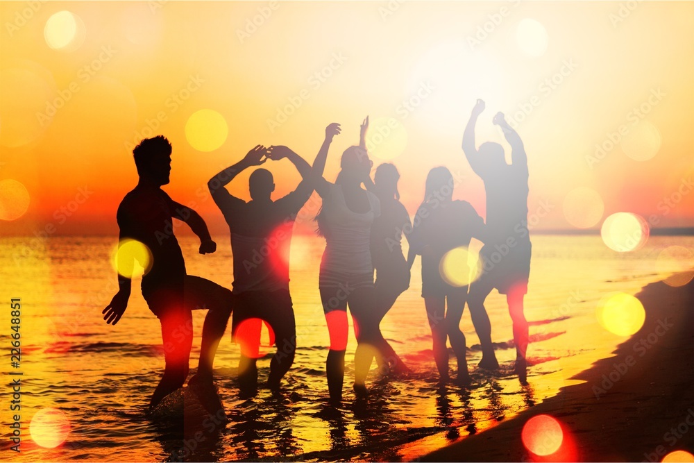 Fototapeta premium Friends jumping on beach at seaside at