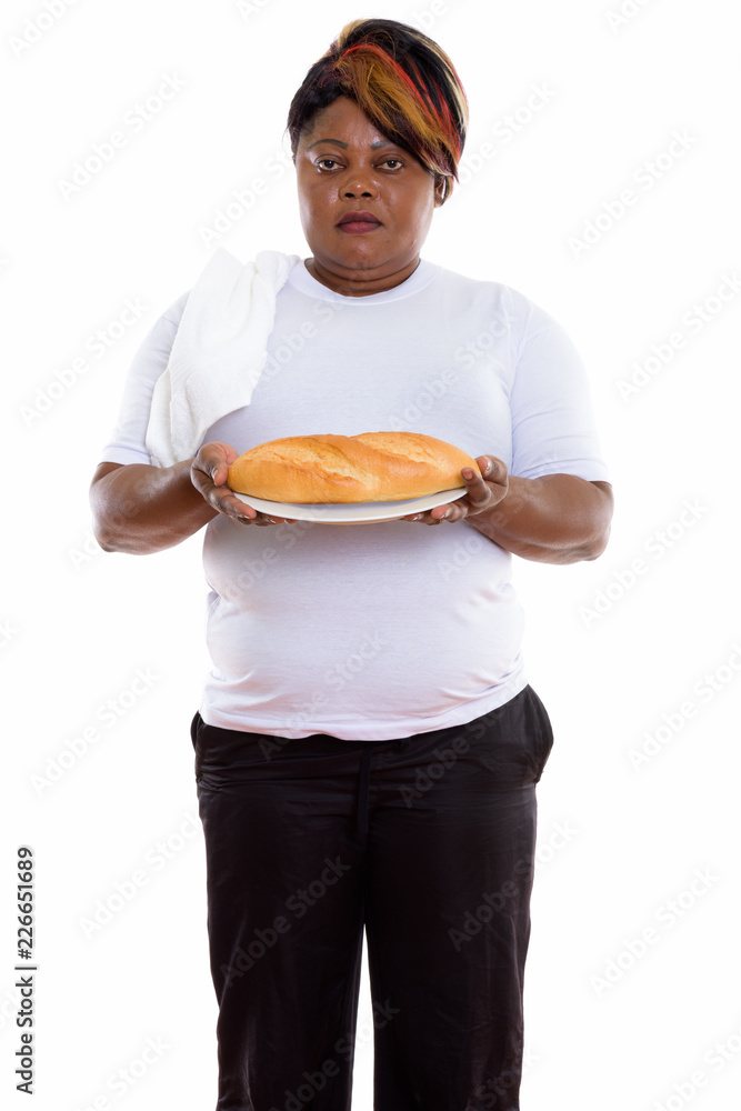 Studio shot of fat black African woman standing while holding br Studio shot of fat black African woman standing while holding br