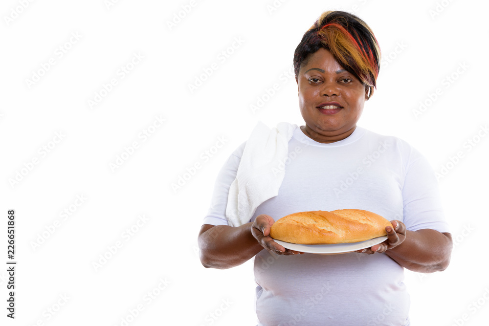 Studio shot of happy fat black African woman smiling while holdi