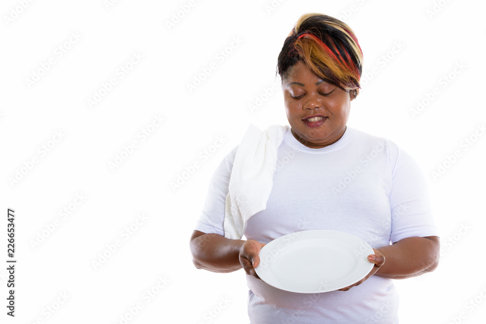 Studio shot of happy fat black African woman smiling while looki Studio shot of happy fat black African woman smiling while looki