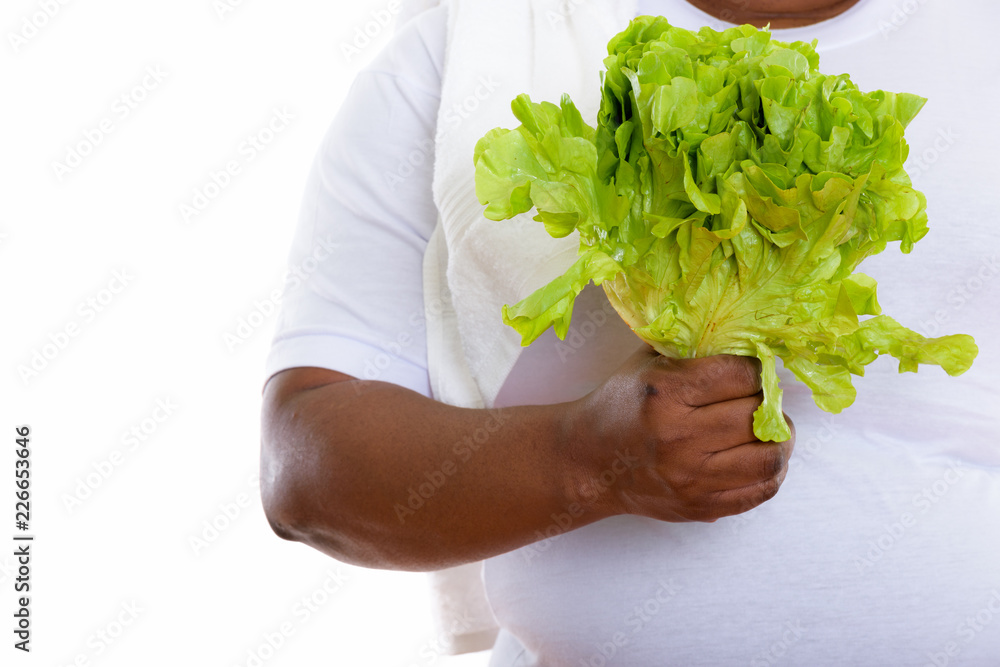 Studio shot of fat black African woman holding lettuce