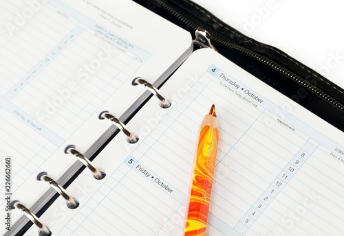 Pencil Pointing at a Day in Calendar Close-Up photo