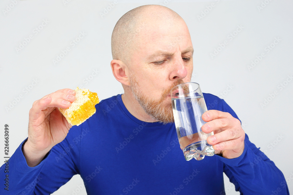 the man offers to eat comb honey and a glass of water. Healthy diet the man offers to eat comb honey and a glass of water. Healthy diet