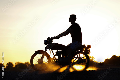 Silhouette of boy on motorbike