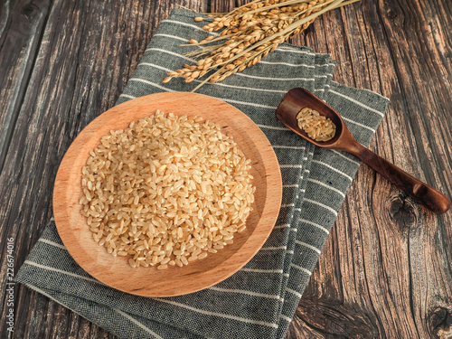 Tableau sur toile brown rice in a wooden bowl with spoon