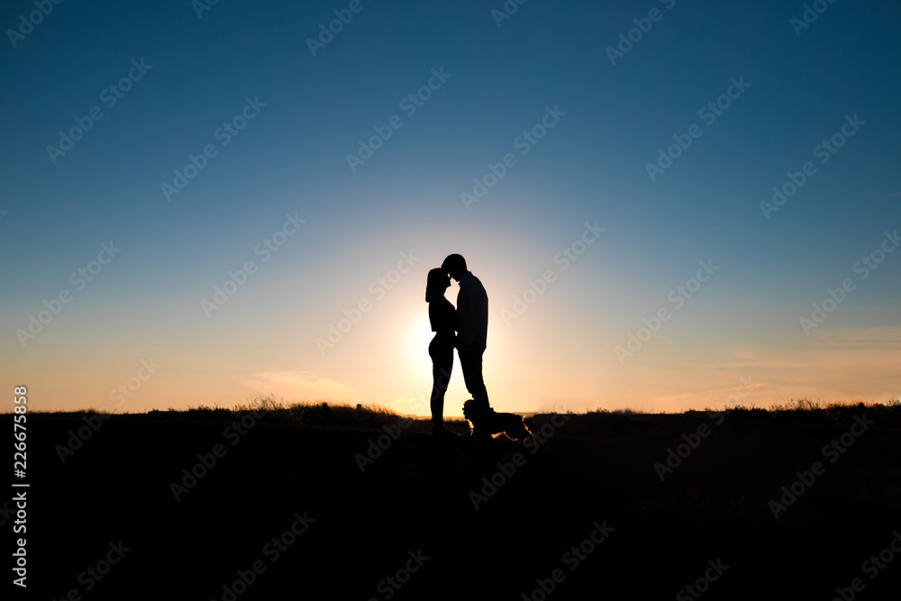 Fototapeta premium Romantic couple hug at sunset on background.