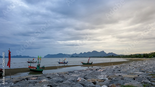 Seashore view in twilight period. A beautiful nature of bay at Pranburi district , Prachub Kiri Khan, Thailand. Fishing boats float in front of beach after fishing. Photo at fisherman village in rural