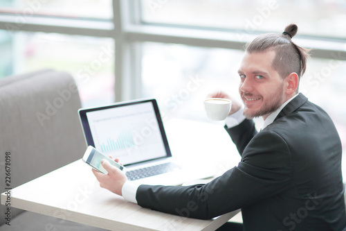 successful businessman is drinking coffee,sitting at his Desk
