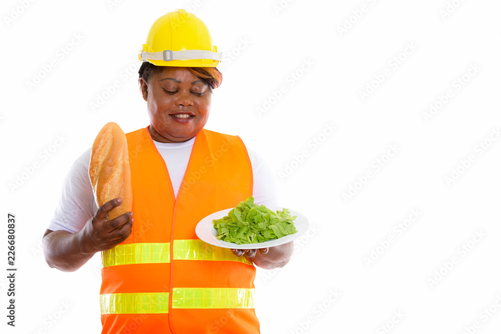 Studio shot of happy fat black African woman construction worker Studio shot of happy fat black African woman construction worker