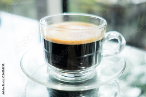 food background cup of coffee on glass table in morning restaurant