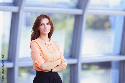 modern business woman standing near a large window in the office. Free Download modern business woman standing near a large window in the office. - GFXLoad