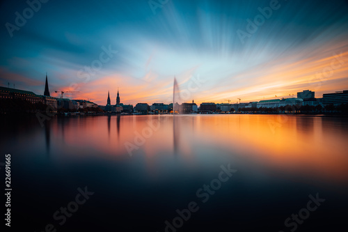 Panoramic view of Binnenalster, Inner Alster Lake in golden and blue evening light at sunset, Hamburg, Germany. Blue hour. Long exposure