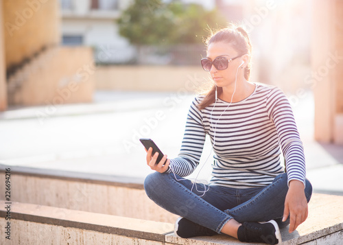 Portrait of young female using smartphone .