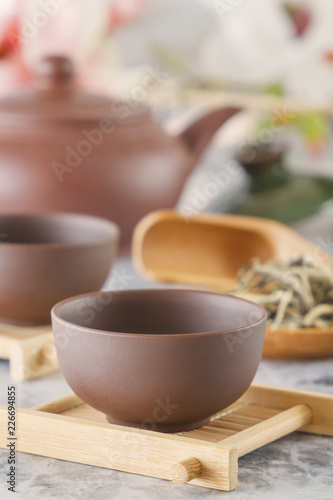 brown ceramic teapot with cups on special wooden coasters is prepared for a traditional Asian tea ceremony