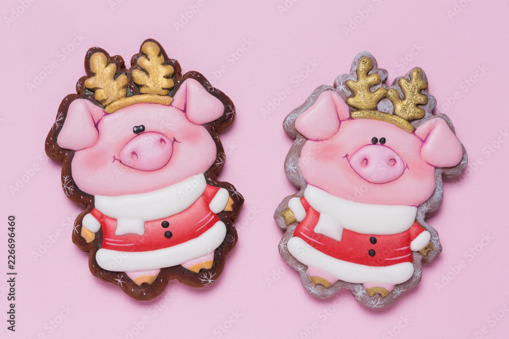 two honey cakes in the shape of pink piglets with golden horns on a pink background, minimal concept of christmas, finances and savings two honey cakes in the shape of pink piglets with golden horns on a pink background, minimal concept of christmas, finances and savings