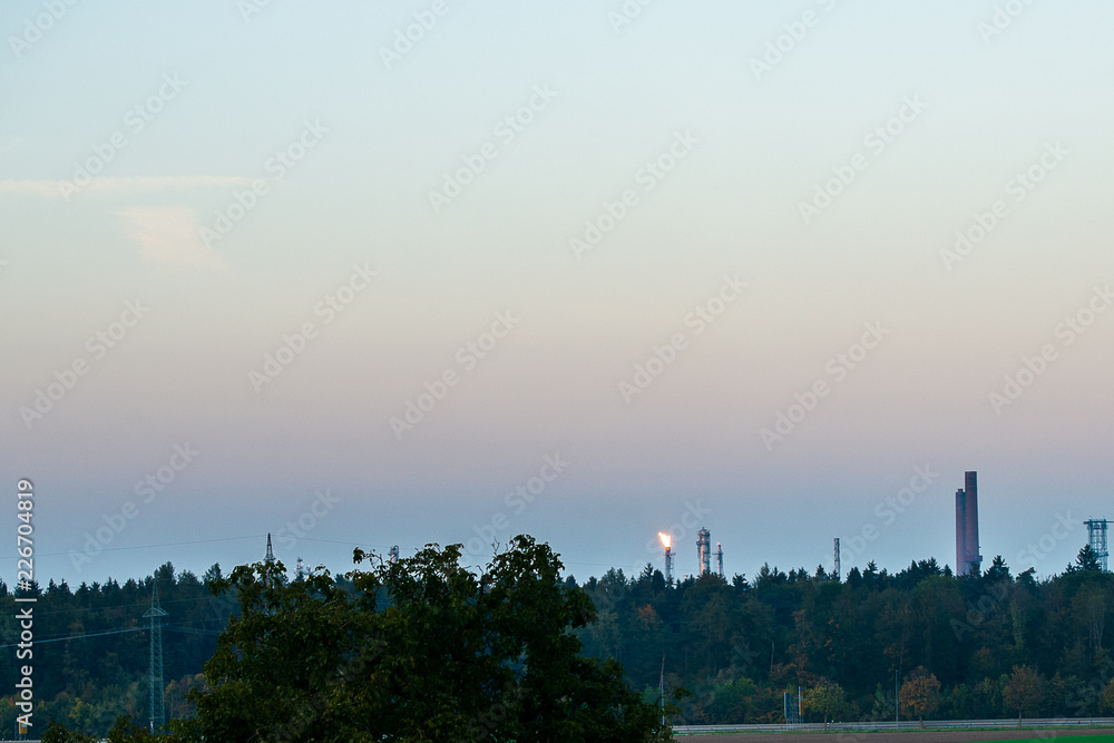 View of Oil refinery burning excess gas in the evening