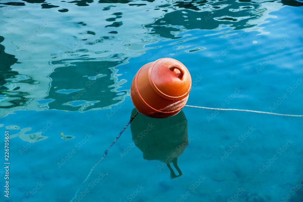Orange buoy in the sea water 