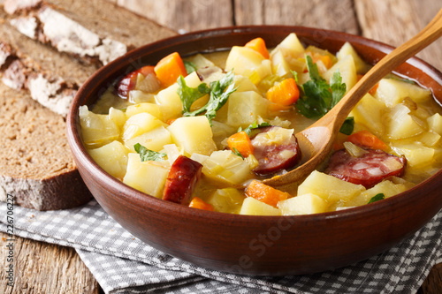 Traditional German kartoffelsuppe potato soup with sausages in a bowl close-up. horizontal