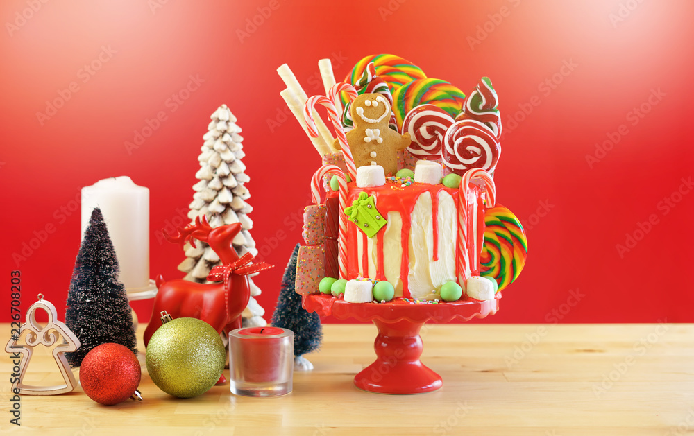 On trend festive candyland Christmas drip cake on red background.  Stock-Foto | Adobe Stock