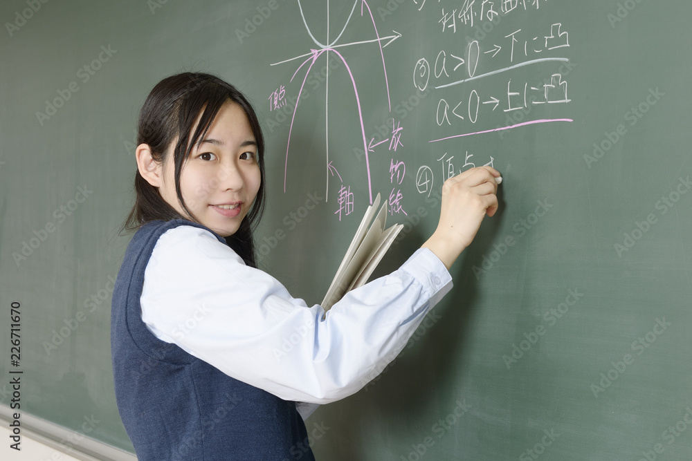 黒板に数式を書き込む女子高校生