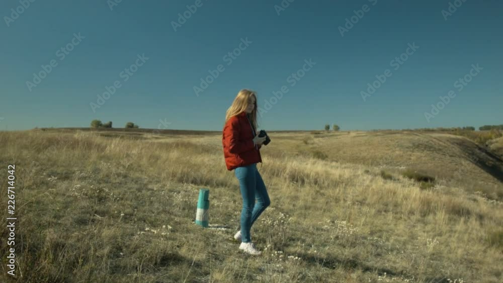 Young beautiful girl makes photos of the surrounding landscape. Girl you are a hill. Sunny day. Rest and travel. Young beautiful girl makes photos of the surrounding landscape. Girl you are a hill. Sunny day. Rest and travel.