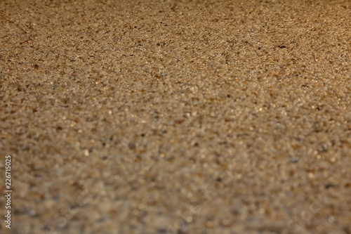 красивый песочный фон из мелких бежевых камней, крупным планом 