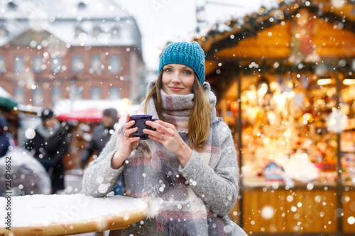 Wall Mural woman drinking hot punch on German Christmas market.