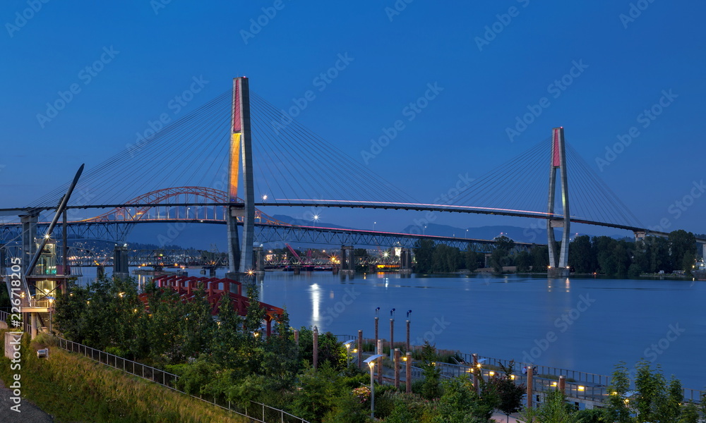 Pattullo Bridge, Sky Train Bridge  and Railroad Track over the Fraser River between New Westminster and Surrey, Promenade quay at Fraser River in New Westminster city in night time.  British Columbia 