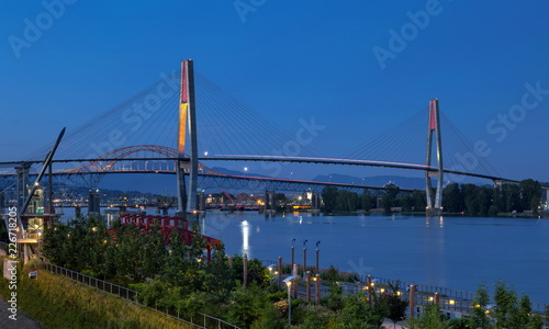 Pattullo Bridge, Sky Train Bridge and Railroad Track over the Fraser River between New Westminster and Surrey, Promenade quay at Fraser River in New Westminster city in night time. British Columbia 