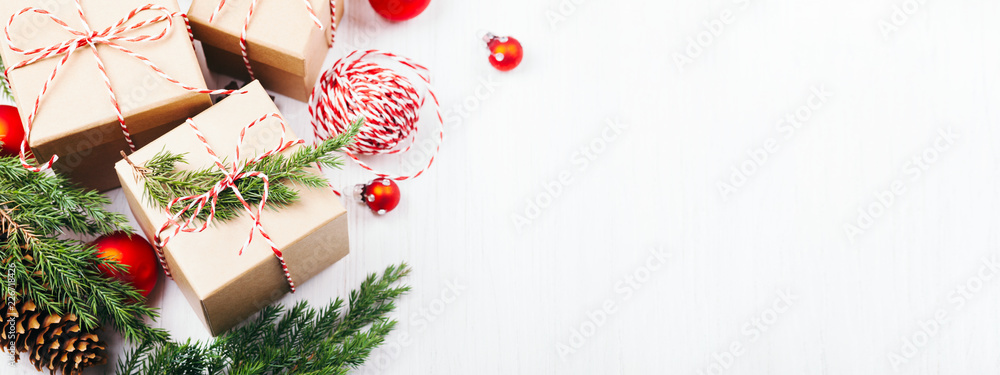 Christmas gift boxes collection with evergreen branches, candy cane Christmas rope and red Christmas balls. Angle view. Copy space, banner for website.