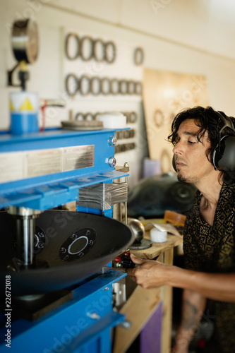 Craftsman in his workshop making design and construction of Handpan, a metal percussion instrument.