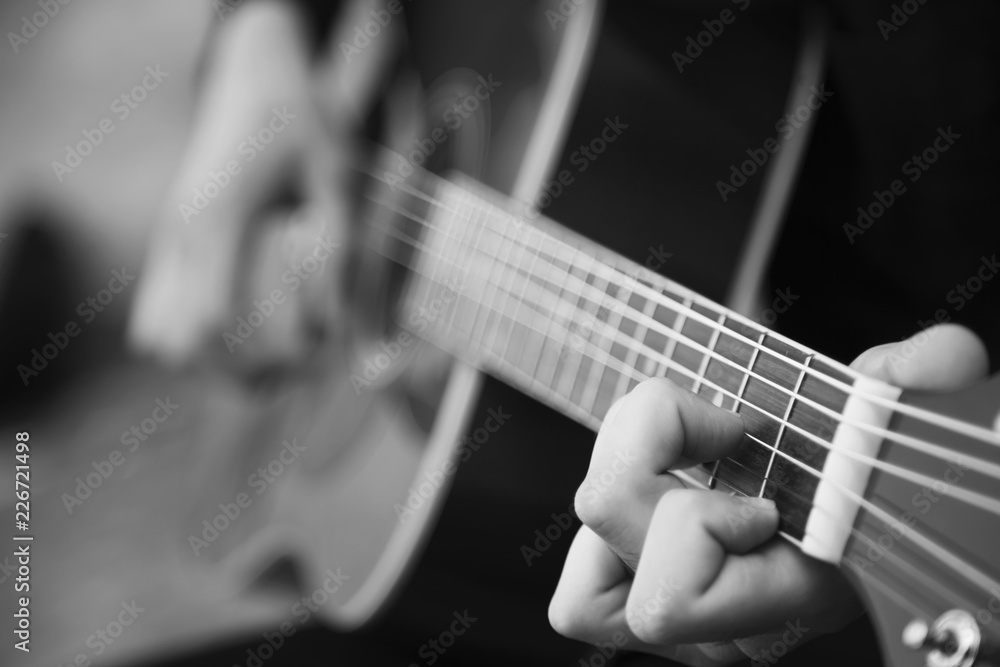 Fototapeta premium Retro styled portrait of man playing the guitar outdoors. Music, art, creativity concept.