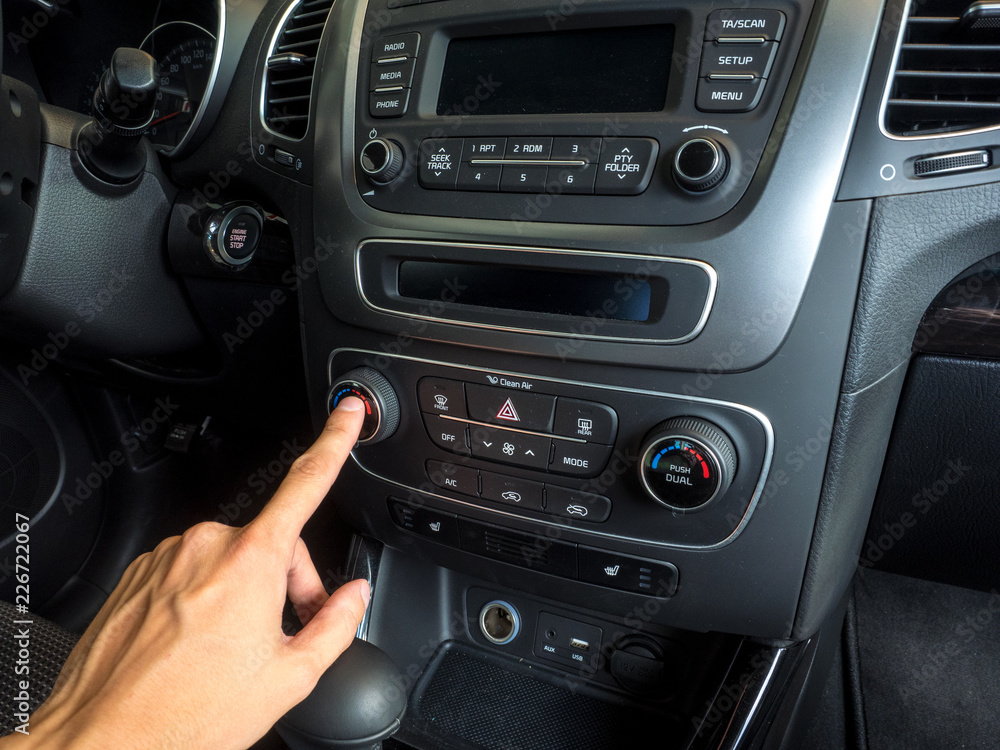 male hand pressing button in modern car. Hand on the dashboard in a car