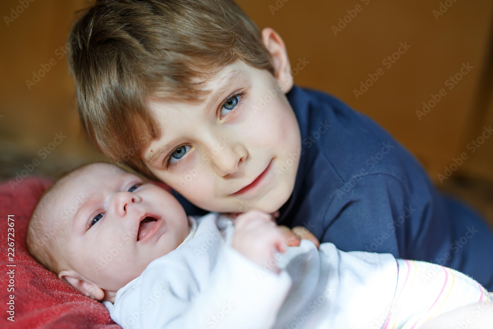 Happy little kid boy with newborn baby sister girl Happy little kid boy with newborn baby sister girl