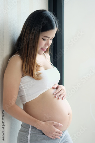 Pregnant woman is holds her hands on her swollen belly. Free Download Pregnant woman is holds her hands on her swollen belly. - GFXLoad