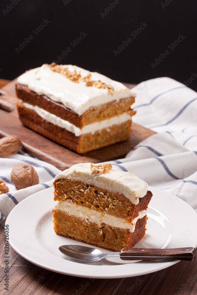 A slice of carrot cake on wooden background