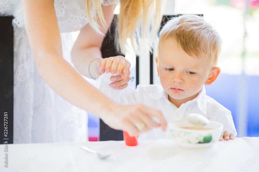 Cute toddler boy eating soup with spoon at home Cute toddler boy eating soup with spoon at home